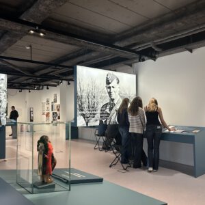 Schüler die sich in einer politischen Ausstellung Ausstellungsobjekte anschauen.