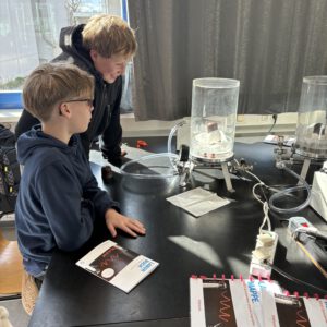 Zwei Schüler, die Experimente in einer Vakuumkapsel beobachten