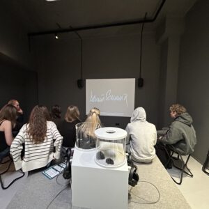 Schüler sitzen in einem Raum vor einem Bildschirm.